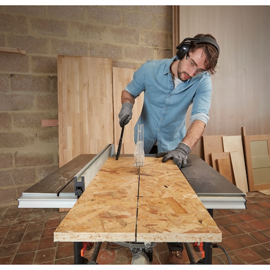 BLACKDECKER BES720 table saw cutting plywood in workshop, photo shows tool in use with safety gear.